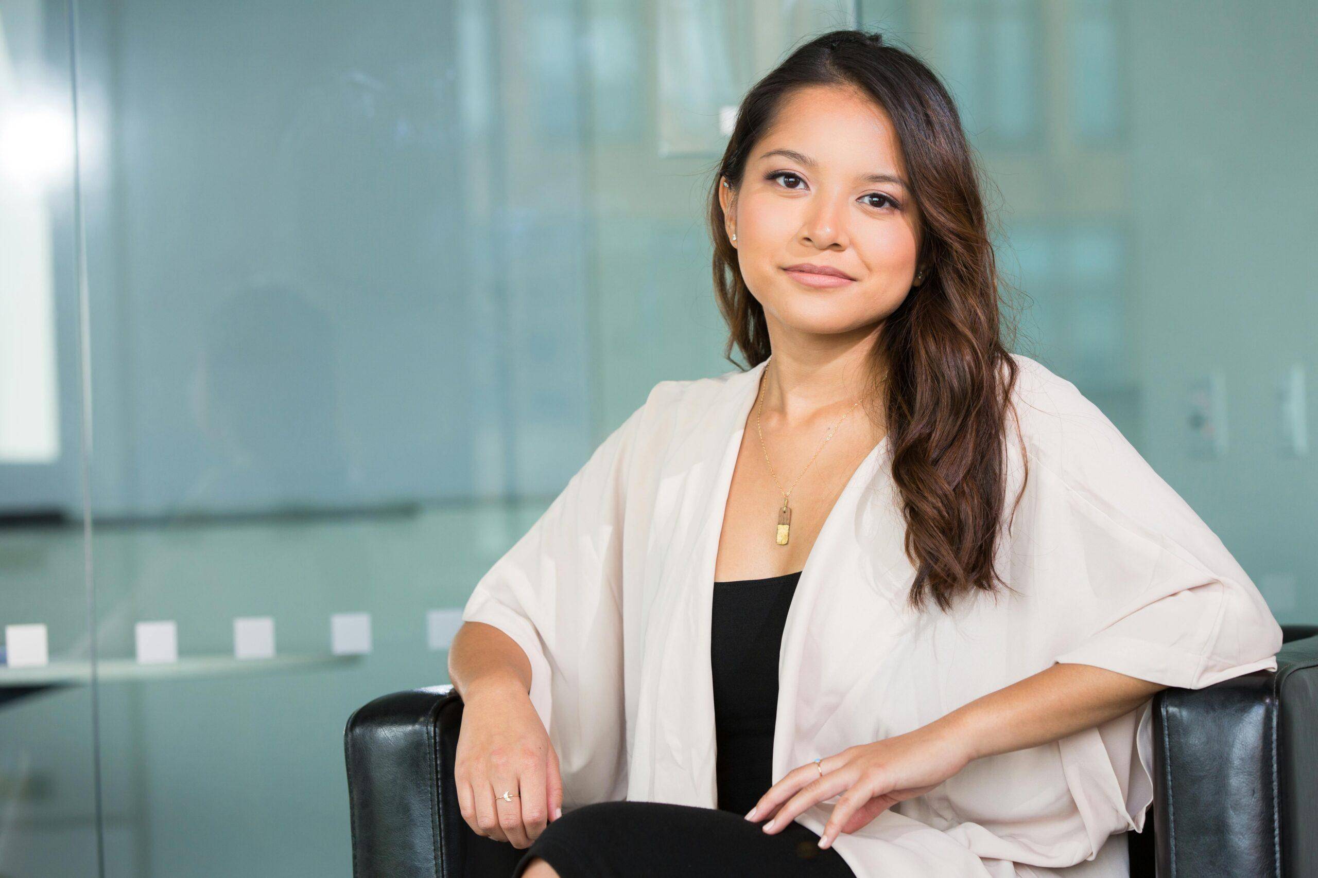 A professional Asian businesswoman sitting confidently in a modern office setting. pexels-photo-1181690-1181690